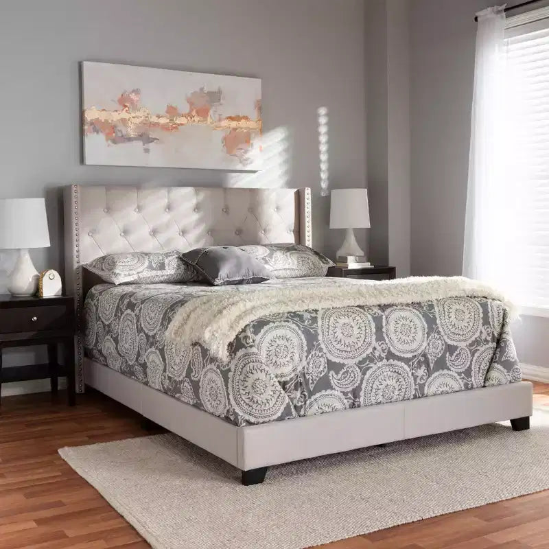 Lit plateforme king size gris tapissé avec tête de lit capitonnée à oreilles
