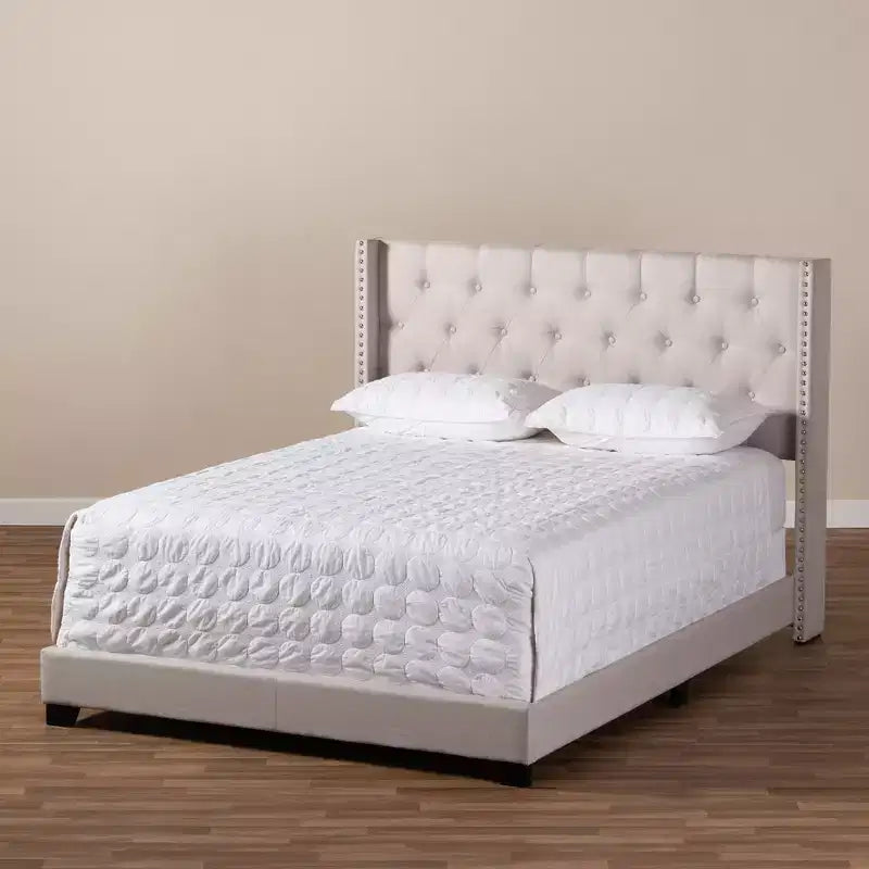 Lit plateforme king size gris tapissé avec tête de lit capitonnée à oreilles
